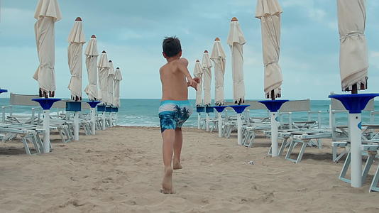 在海边跑步的活跃男孩想在海边跑步视频的预览图