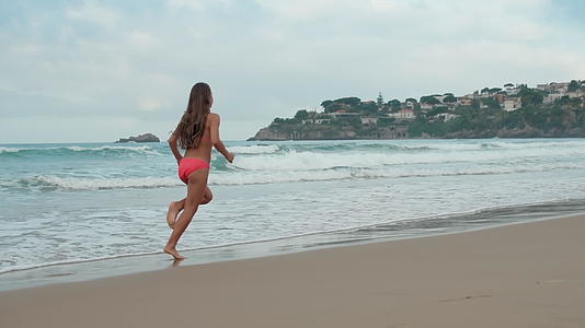 年轻女子在海岸线上奔跑视频的预览图