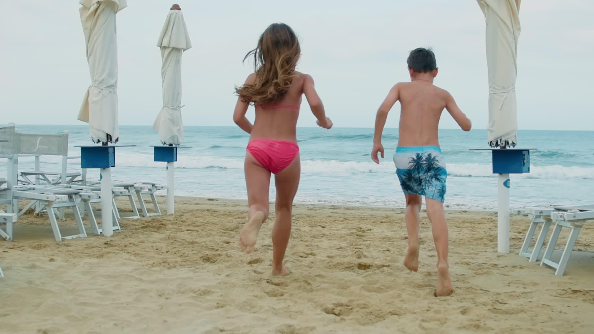 孩子们在海滩上玩得很开心男孩和女孩在海滩上跑步视频的预览图