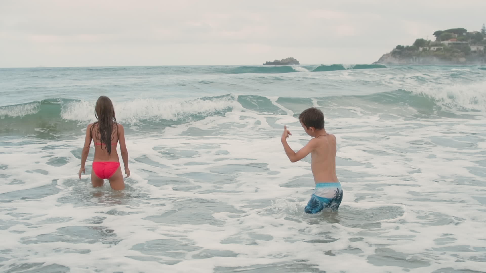 孩子们在海滩上快乐地游泳孩子们在海浪中玩耍视频的预览图
