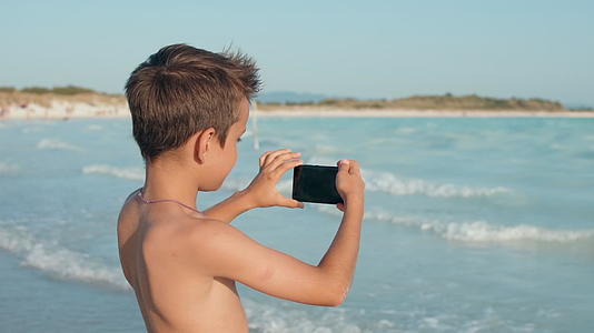 小那还在海边用手机拍照视频的预览图