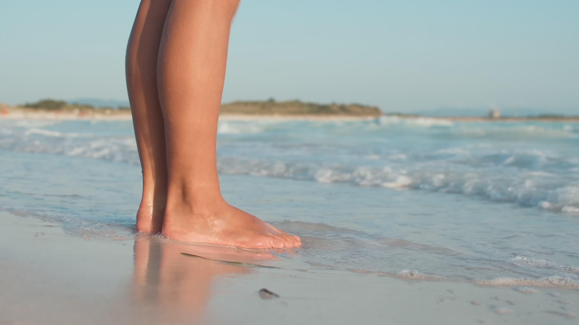 海浪冲向海滩女人的脚视频的预览图