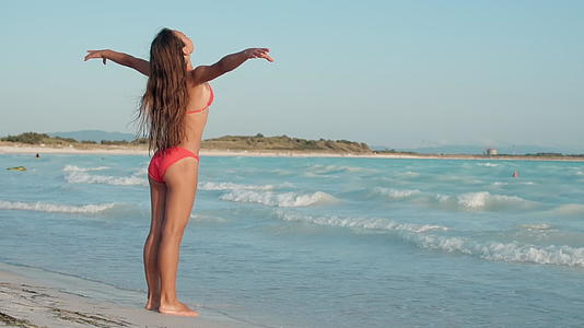 夏天美丽的海边女孩张开双臂感到舒适视频的预览图