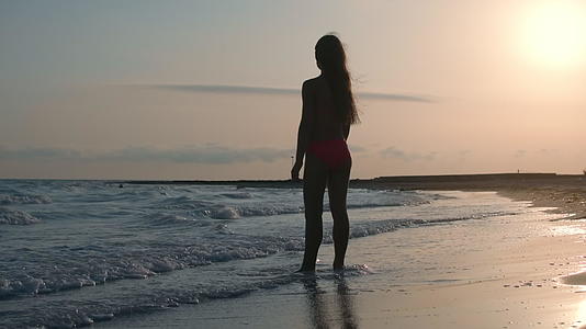 小女孩在沙滩上度过了闲暇时光背光美丽背影美丽视频的预览图