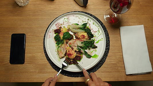 女性晚上在餐厅餐桌上吃素食晚餐视频的预览图