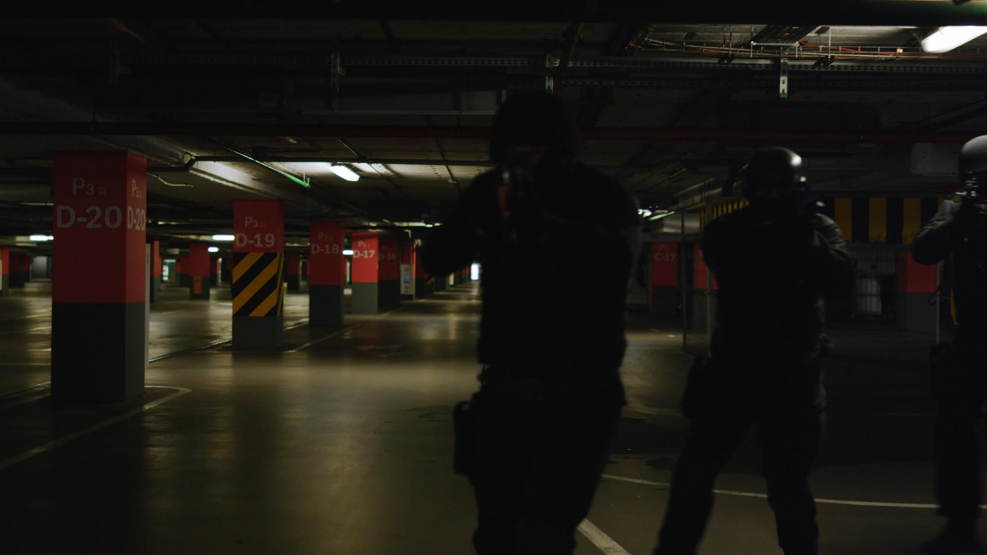 特警特警队在黑暗中检查地下停车区视频的预览图