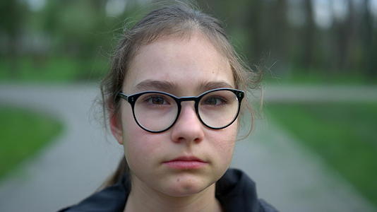 公园里戴着眼镜的小女孩严肃地面对着镜头视频的预览图