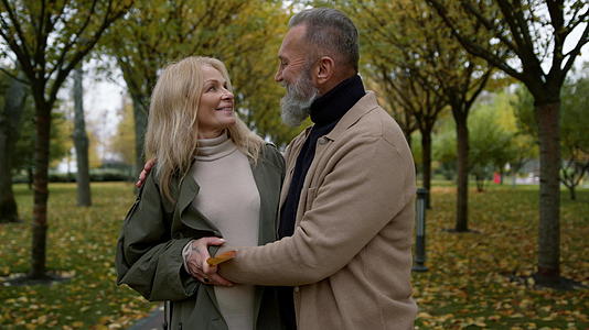 一对浪漫情侣白天站在秋天公园的特写镜头快乐的恋人视频的预览图