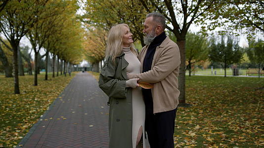 浪漫的情侣在公园里用秋天的背景拥抱视频的预览图