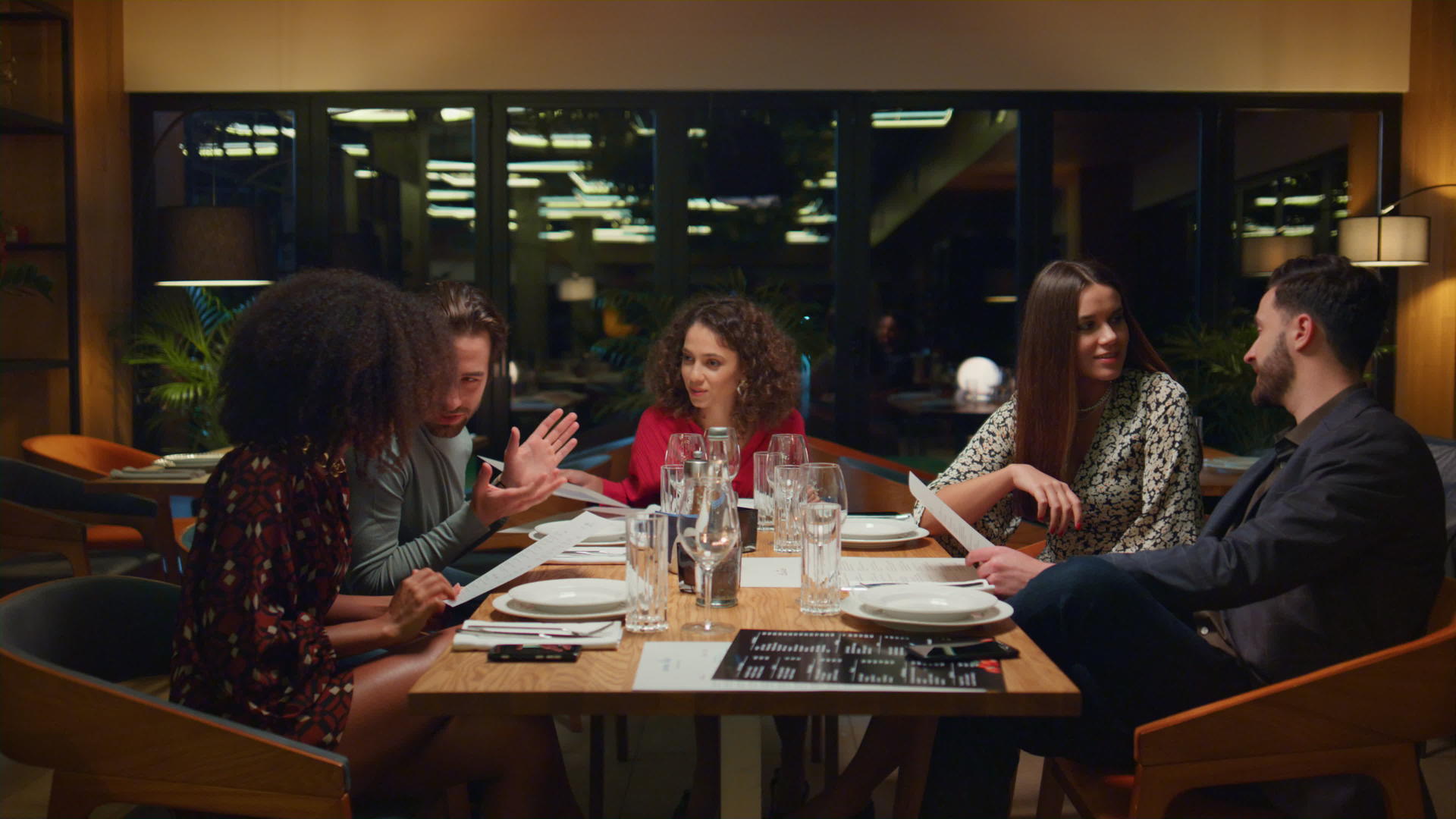 晚上不同的团体坐在餐馆的桌子上视频的预览图