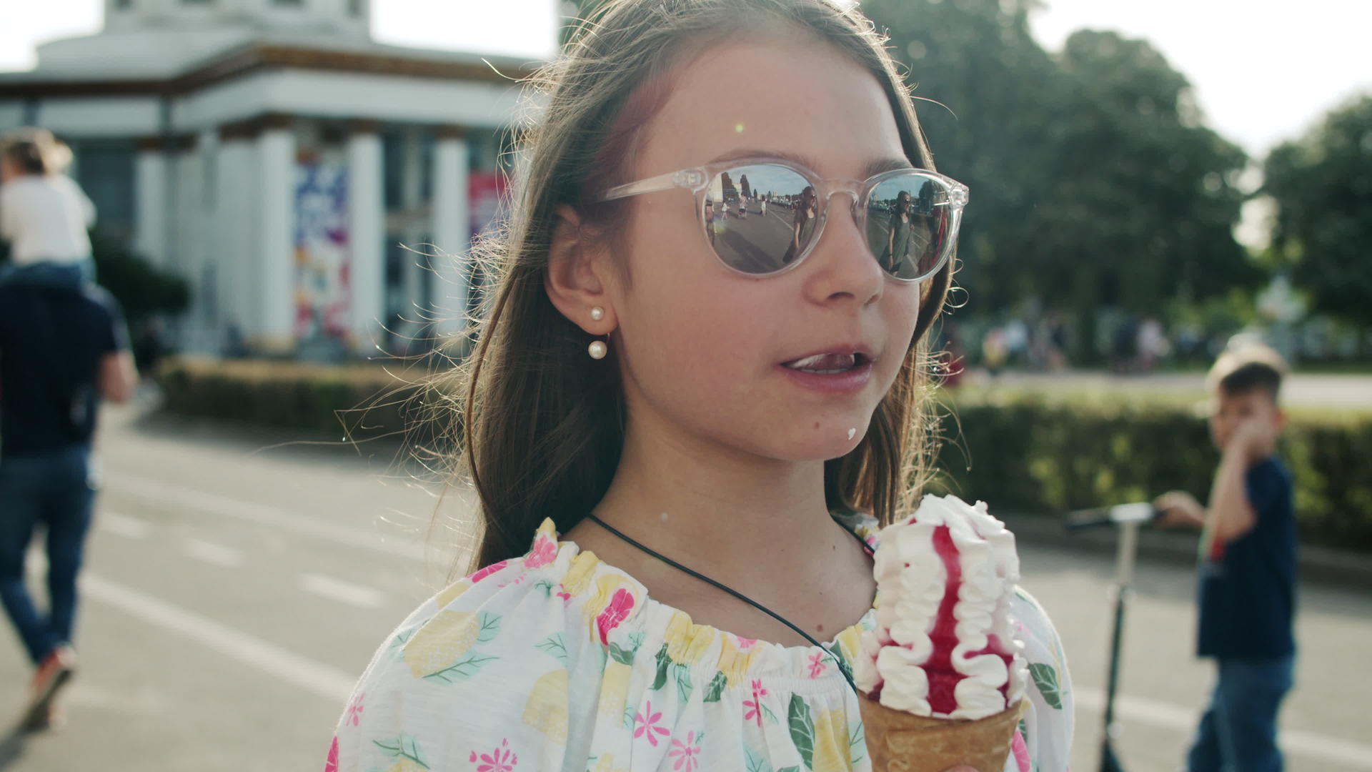 漂亮的小女孩在街上吃冰淇淋视频的预览图