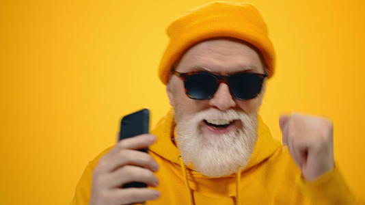 戴墨镜的时髦白胡子老年男人在听音乐视频的预览图
