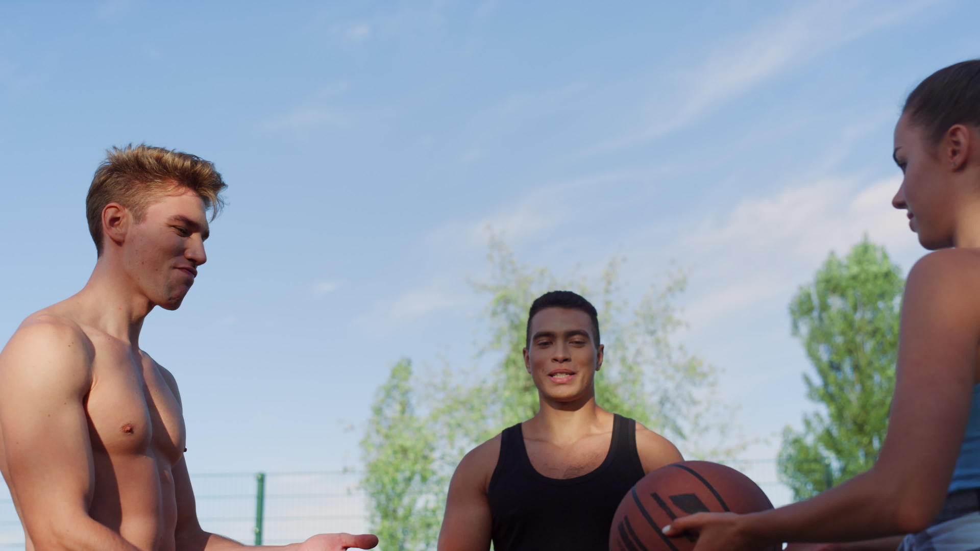 三名混合种族运动员在体育操场训练街头篮球视频的预览图