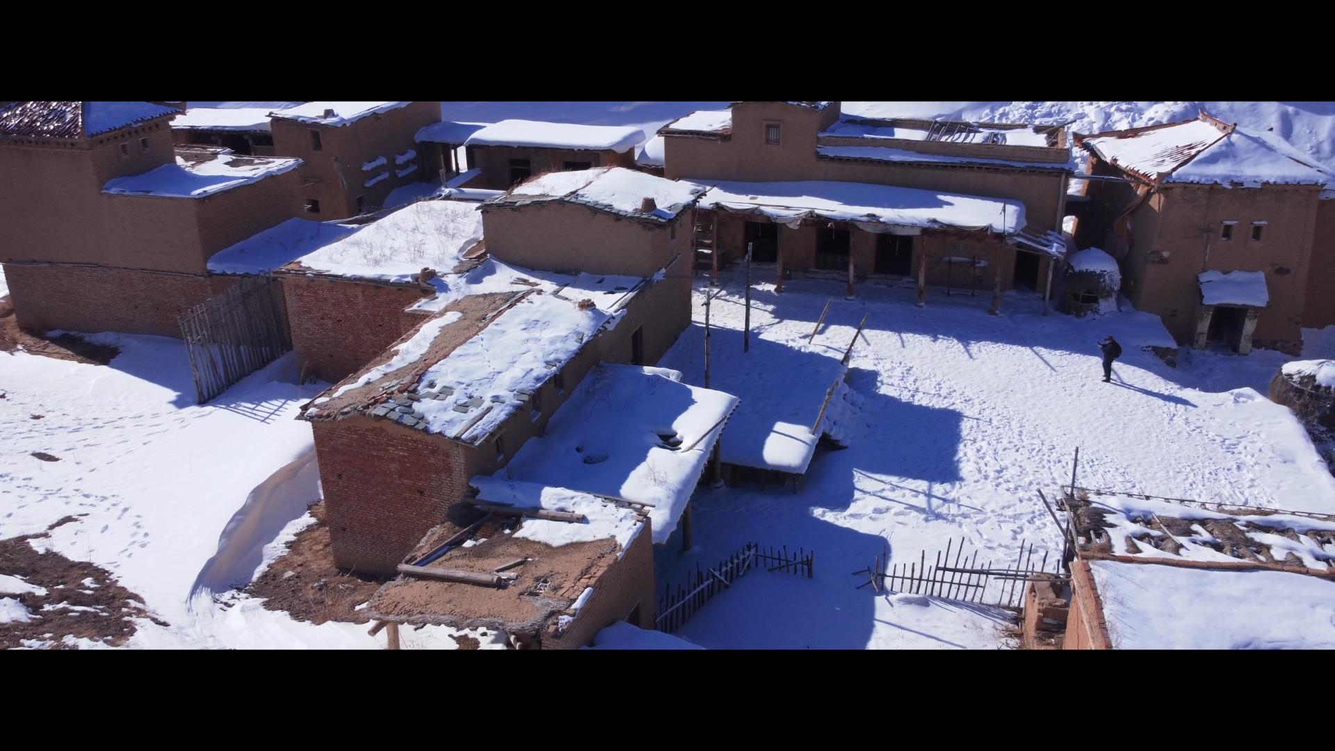 航拍新疆雪地坑中的老房子视频的预览图