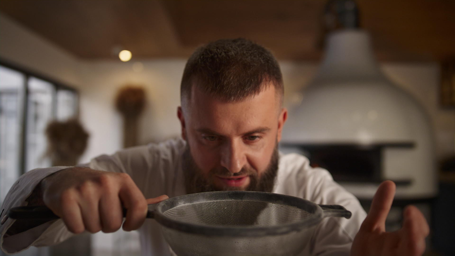 面包师在烹饪餐厅使用筛子面粉视频的预览图