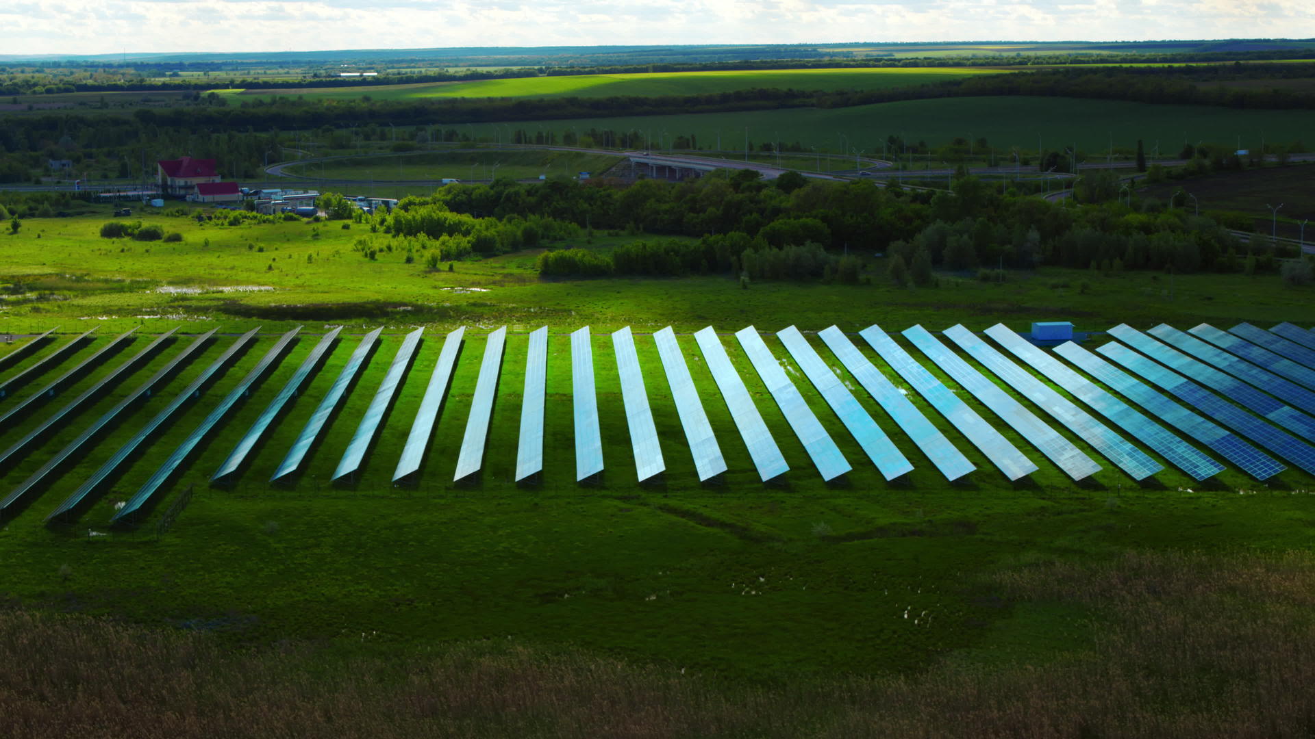 太阳能电池板公园绿色田野中的无人机视图视频的预览图