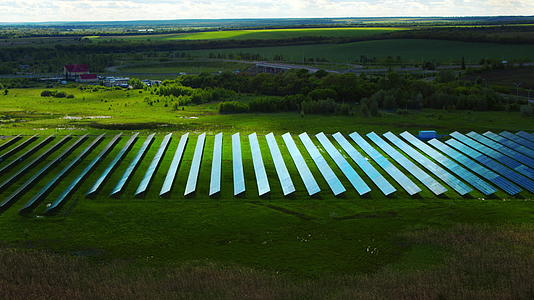 太阳能电池板公园绿色田野中的无人机视图视频的预览图
