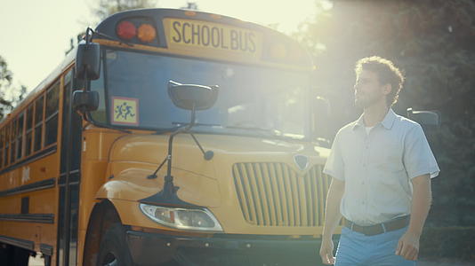 年青的校车司机独自站在学术班车附近视频的预览图