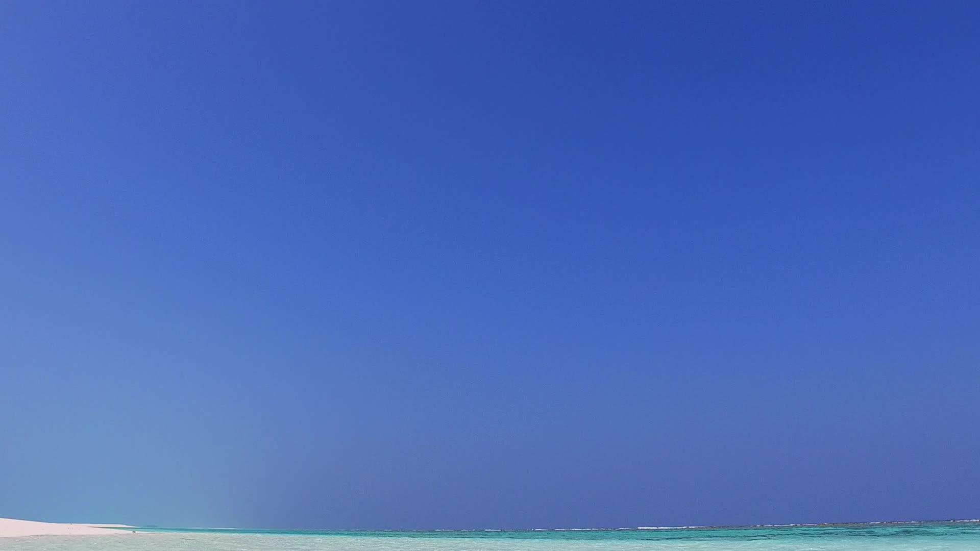 蓝绿环礁湖和珊瑚礁附近的白沙背景阳光明媚的海洋岛屿视频的预览图