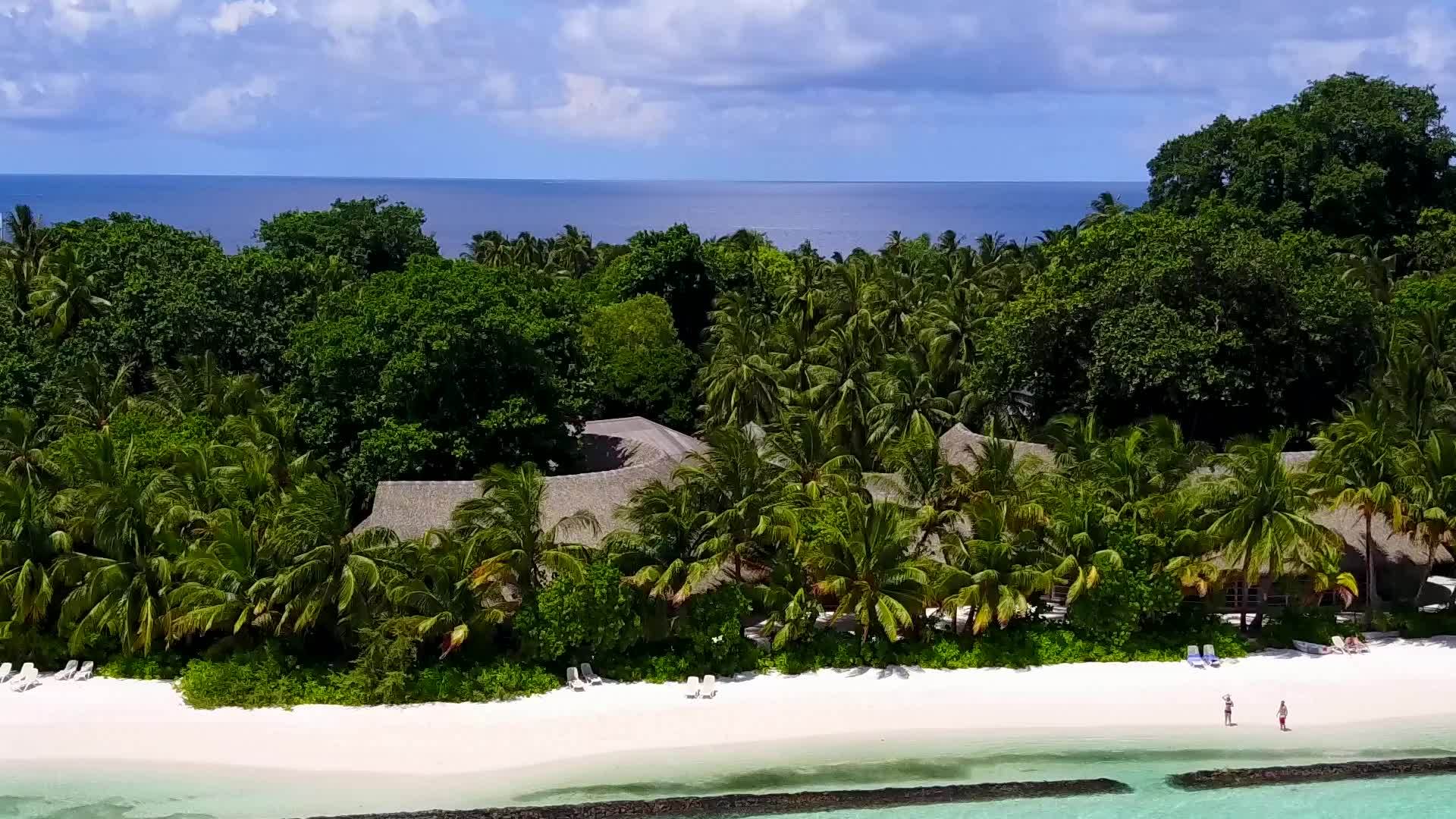 珊瑚礁附近的天空中复制了蓝海和白色沙滩的背景视频的预览图
