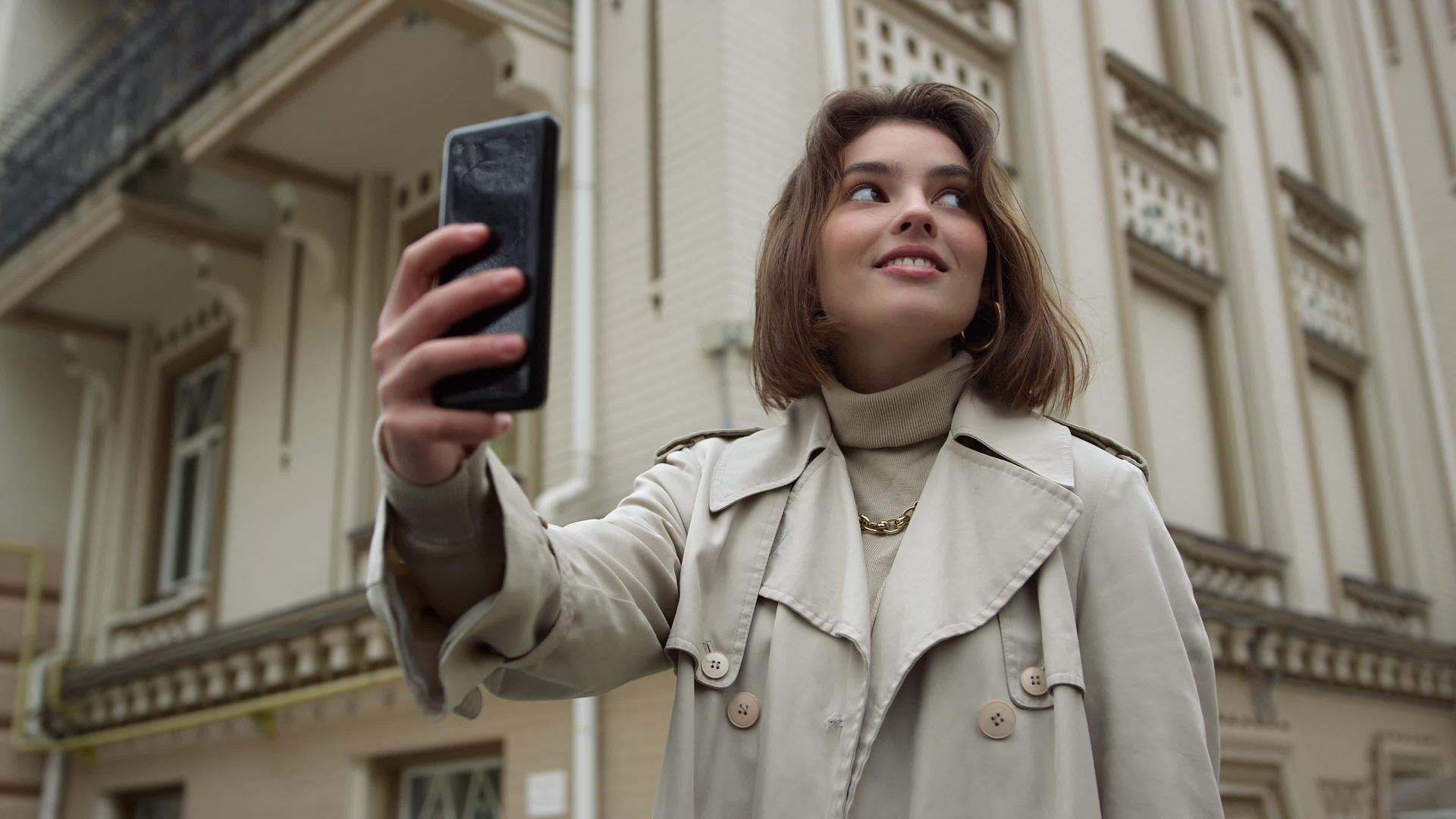 在市区街上自拍的笑女人孩子为手机摄像头视频的预览图