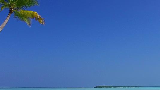靠近海浪的白色沙滩背景下的水蓝色海水近距离欣赏宁静度假视频的预览图