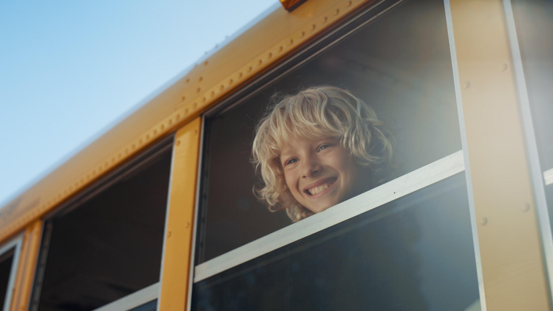 微笑的男孩看着校车窗外视频的预览图