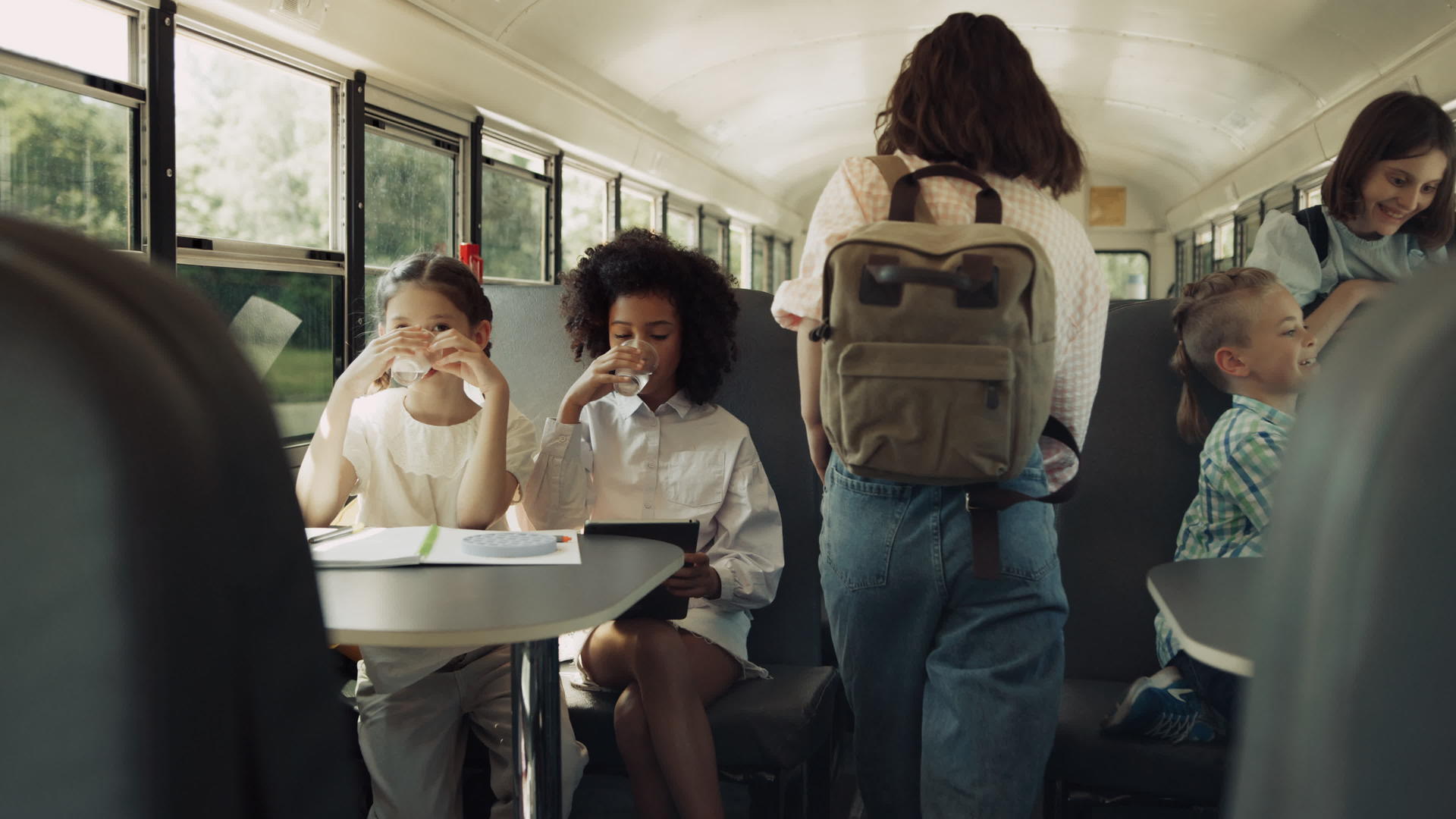 早晨多元文化的学生坐在校车上视频的预览图