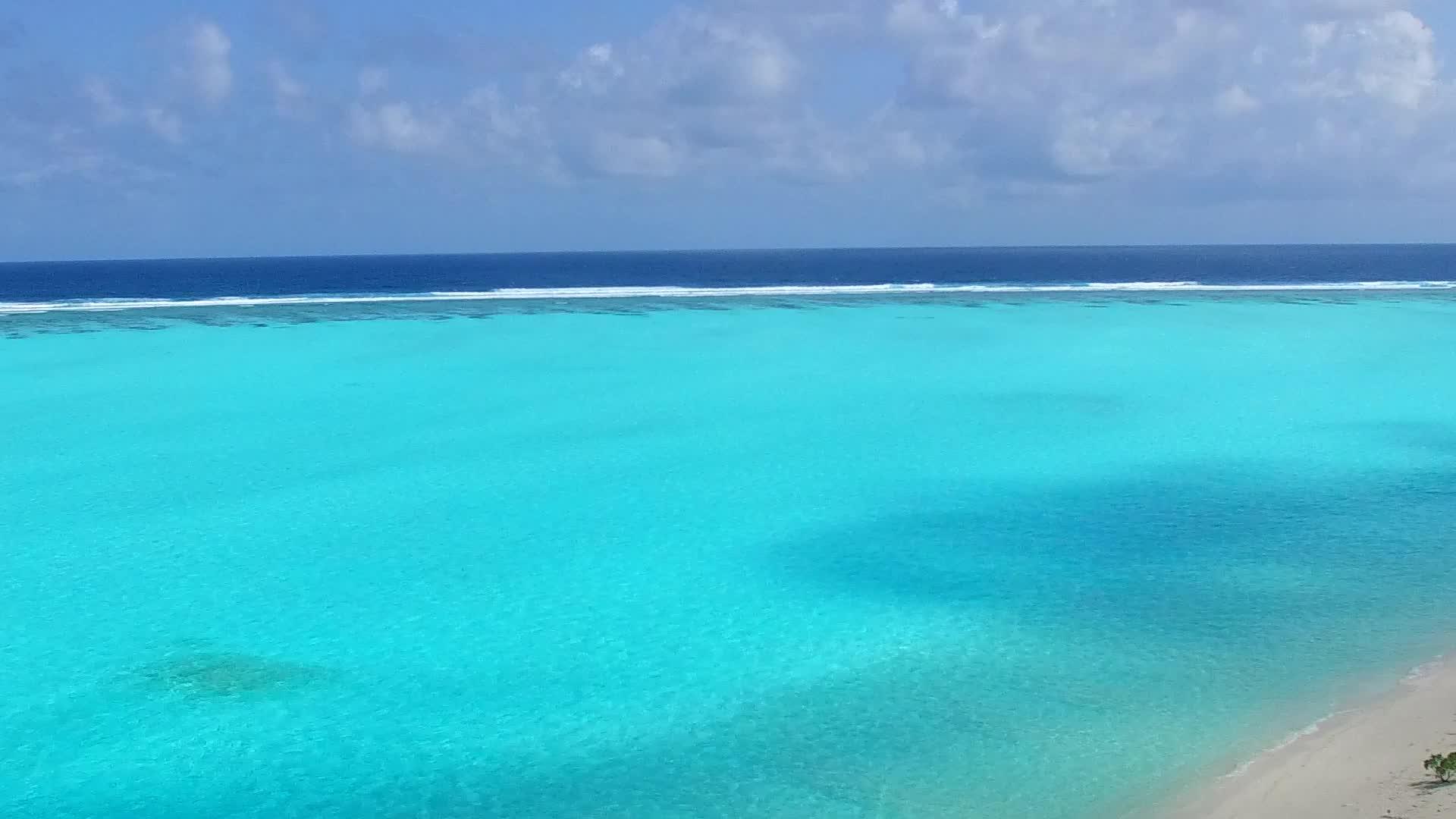 阳光明媚的海滨沙滩度假蓝色的水和海滩附近的白沙背景视频的预览图