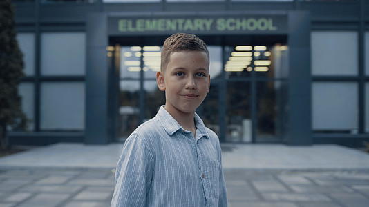 小学小男孩站在学校门口微笑视频的预览图