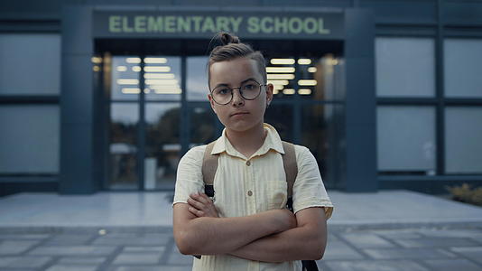 严肃的少年男孩站在学校门口视频的预览图