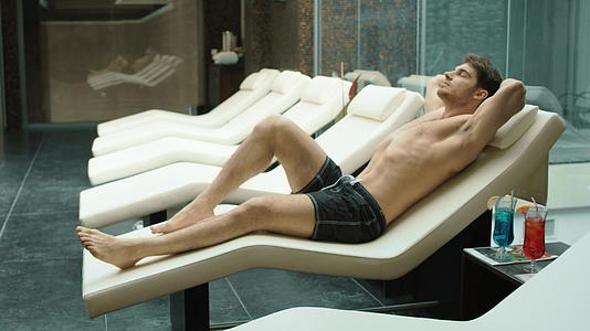男子躺在酒店温泉疗养院的躺椅上视频的预览图
