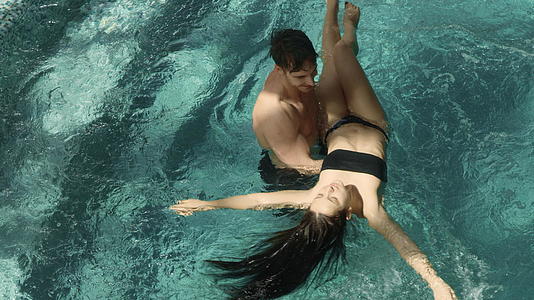 英俊的男人和漂亮的女人在游泳池里两个人在温泉里放松视频的预览图