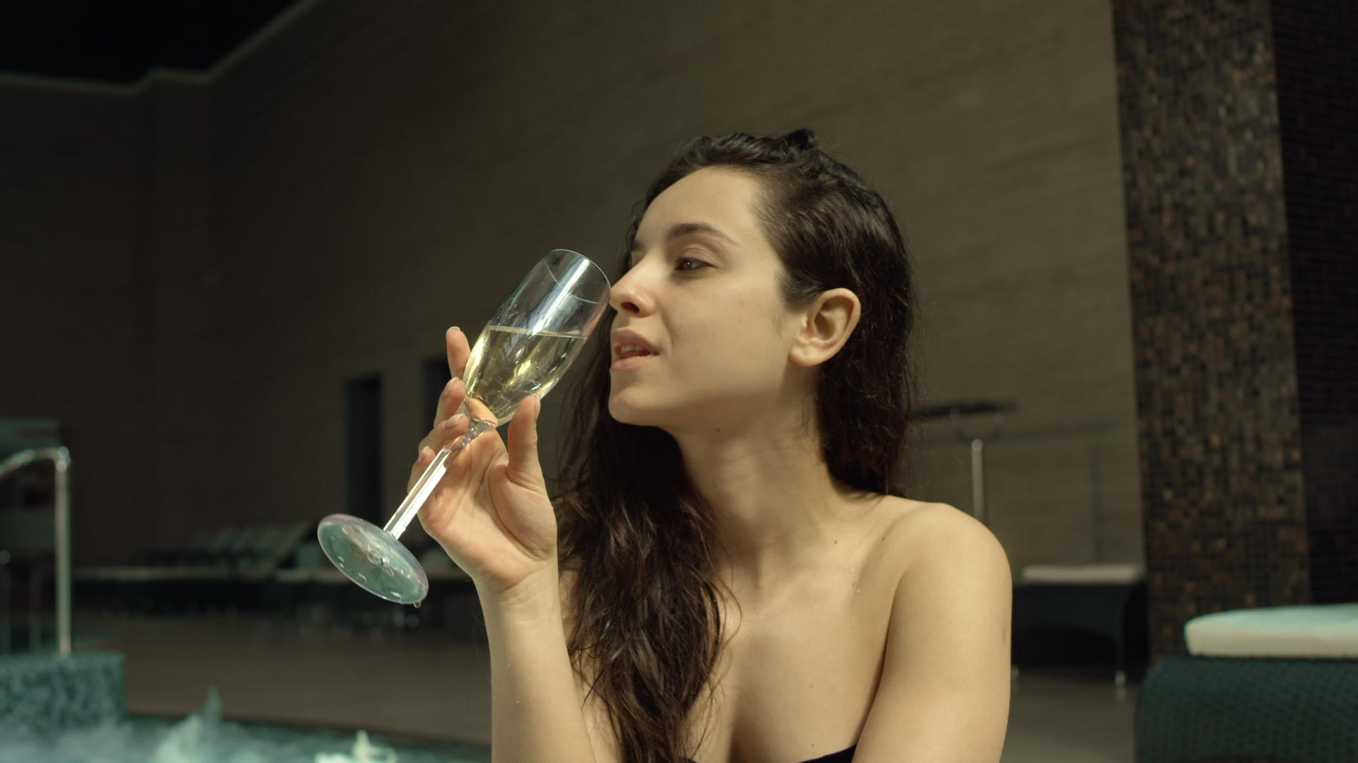 坐在游泳池边的嬉戏女孩喝着香槟视频的预览图
