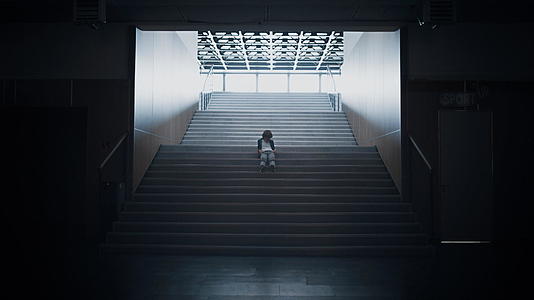 孤独的少年独自坐在黑暗的楼梯上视频的预览图