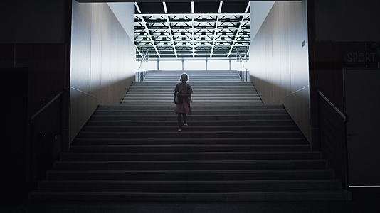 忧心忡忡的女学生独自走下空荡荡的楼梯视频的预览图