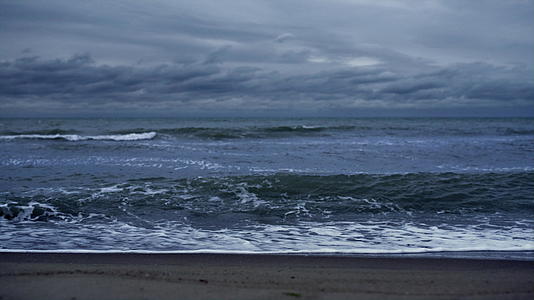 在黑暗的风暴天空中蓝色的波浪撞击着大海视频的预览图