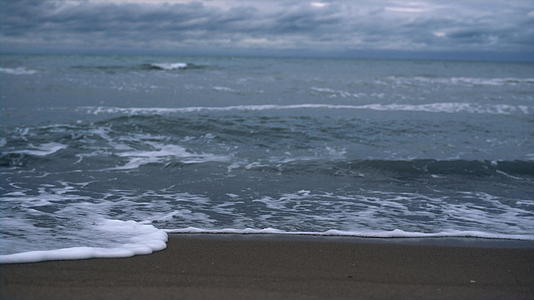 在黑暗的暴风雨天气下海浪在海岸景观的背景下撞击海滩视频的预览图