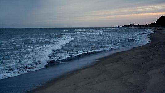 夕阳下的海浪拍打着美丽的沙滩视频的预览图