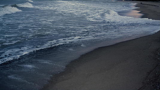 漆黑的海浪拍打着外边的沙滩视频的预览图