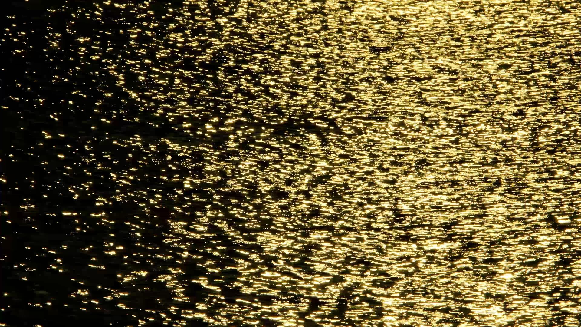 美丽抽象的金色海水背景在柔和的海浪中观察太阳视频的预览图