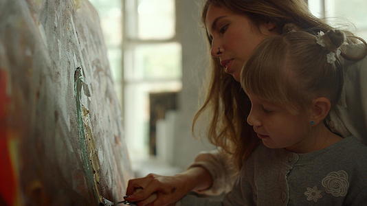 有创意的女画家在室内教小女孩视频的预览图
