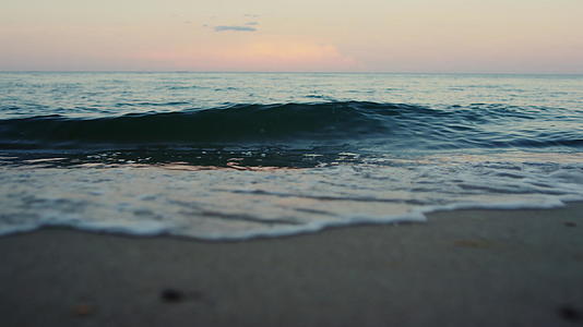 夏天的早晨蓝色的海浪以缓慢的动作打破了沙滩视频的预览图