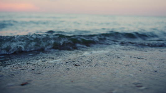 寒冷的早晨蓝色的海浪在沙滩上飞溅视频的预览图