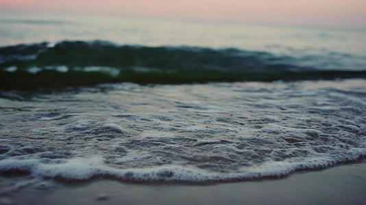 寒冷的早晨海浪在海岸线上溅起沙滩视频的预览图