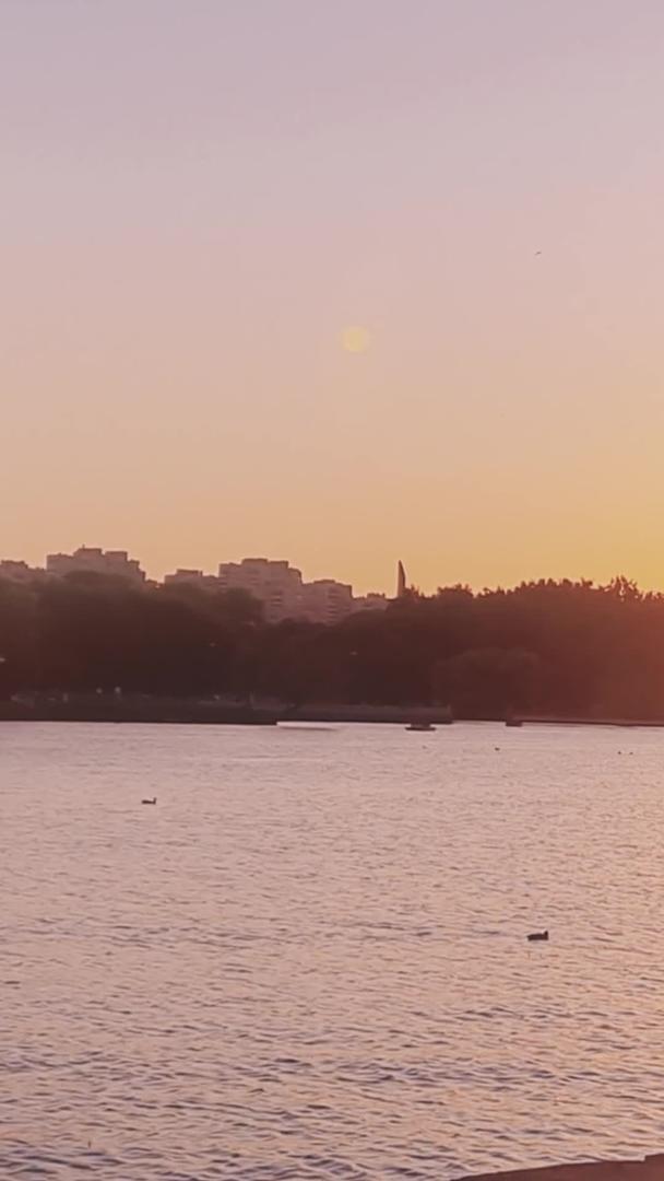 黄昏时分夕阳下河堤漫步的人视频的预览图