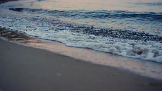 早晨黎明打破沙滩的蓝色冷海浪视频的预览图