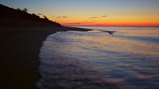 橘黄色的日落和黎明的岩石海滨视频的预览图
