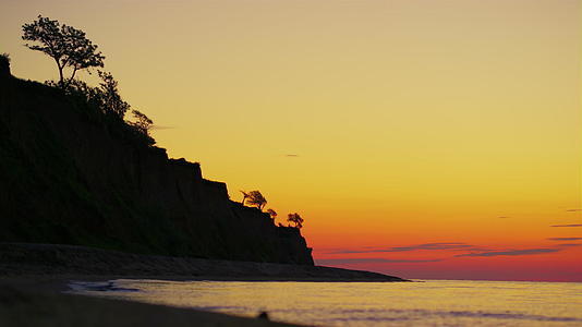 岩石山剪影在黄昏的金色日出和树木视频的预览图