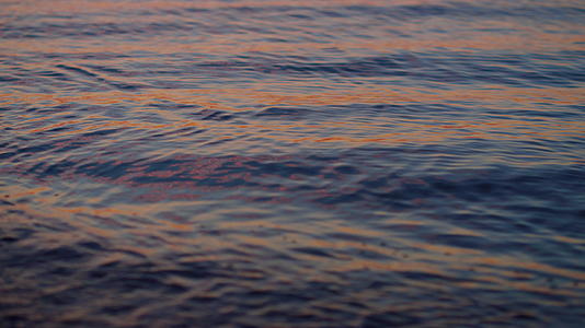 特写镜头海水表面反射紫天夜晚日落黎明视频的预览图